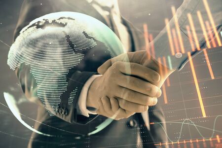 Multi exposure of forex graph and world map on abstract background with two businessmen handshake. Concept of success on international marketsの写真素材