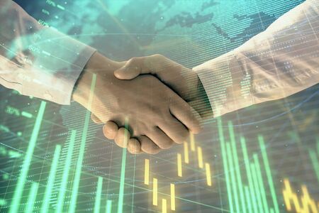 Multi exposure of forex graph and world map on abstract background with two businessmen handshake. Concept of success on international marketsの写真素材