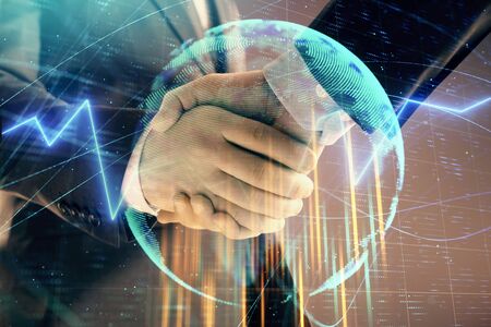 Multi exposure of forex graph and world map on abstract background with two businessmen handshake. Concept of success on international marketsの写真素材