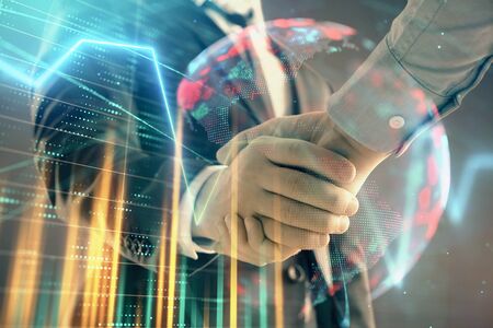 Multi exposure of forex graph and world map on abstract background with two businessmen handshake. Concept of success on international marketsの写真素材