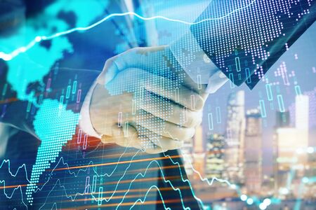 Double exposure of financial chart and world map on cityscape background with two businessmen handshake. Concept of international investmentの写真素材