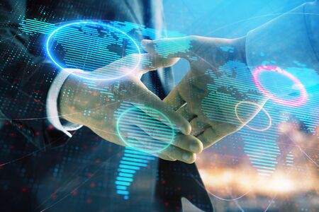 Double exposure of world map on cityscape background with two businessmen handshake. Concept of international businessの写真素材
