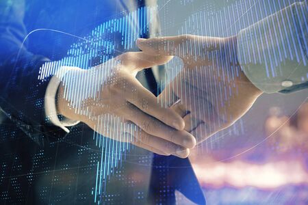 Double exposure of world map on cityscape background with two businessmen handshake. Concept of international businessの写真素材