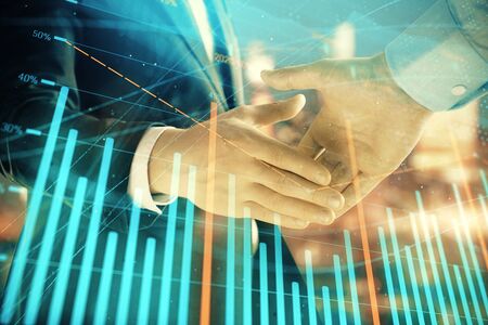 Double exposure of financial chart on cityscape background with two businessmen handshake. Concept of financial analysis and investment opportunitiesの写真素材