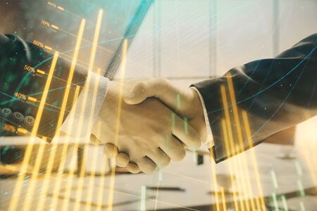 Multi exposure of financial graph on office background with two businessmen handshake. Concept of...