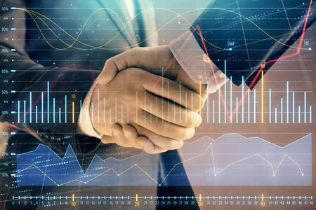 Multi exposure of forex graph on abstract background with two businessmen handshake. Concept of success on stock marketの写真素材