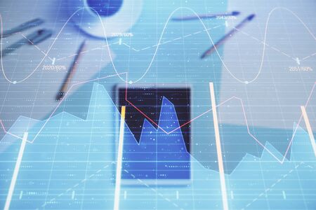 Double exposure of forex graph on digital tablet laying on table background. Concept of market...