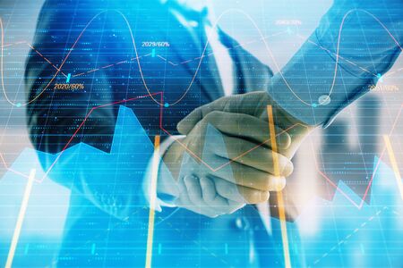 Double exposure of financial graph on cityscape background with two businessman handshake. Concept...