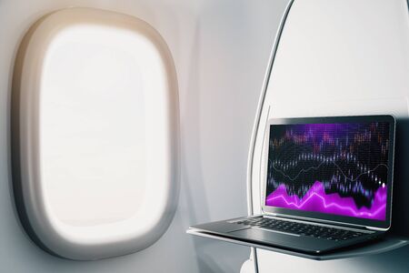 Laptop closeup inside airplane with forex graph on screen. Financial market trading concept. 3d rendering.の写真素材