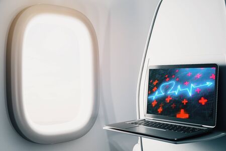 Laptop closeup inside airplane with heart health pic on screen. Medical education concept. 3d rendering.の写真素材