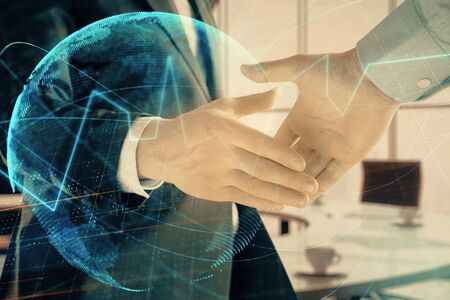 Multi exposure of financial chart and map on office background with two businessmen handshake....