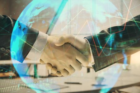 Multi exposure of financial chart and map on office background with two businessmen handshake. Concept of success in businessの写真素材