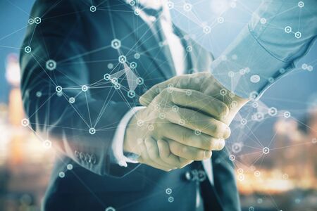 Double exposure of abstract technology drawing on cityscape background with two businessmen handshake. Concept of tech role in businessの写真素材