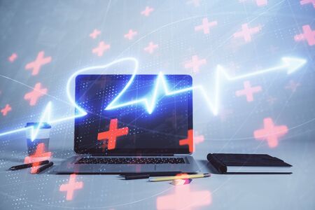 Heart hologram with desktop office background. Double exposure. Concept of medical educationの写真素材