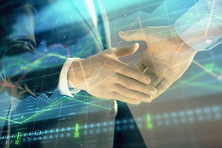 Multi exposure of forex graph on abstract background with two businessmen handshake. Concept of success on stock marketの写真素材