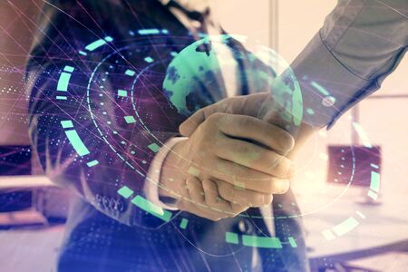 Multi exposure of world map on office background with two businessmen handshake. Concept of international businessの写真素材