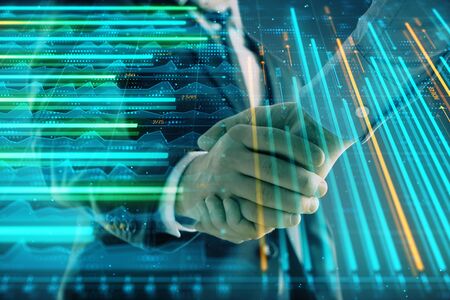 Multi exposure of forex graph on abstract background with two businessmen handshake. Concept of...