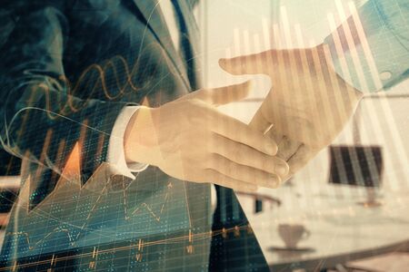 Multi exposure of financial graph on office background with two businessmen handshake. Concept of success in businessの写真素材