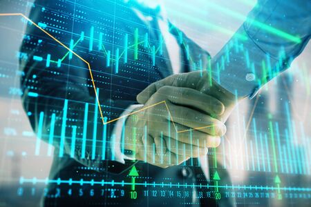Double exposure of financial graph on cityscape background with two businessman handshake. Concept of stock market dealの写真素材