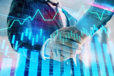 Double exposure of financial graph on cityscape background with two businessman handshake. Concept...