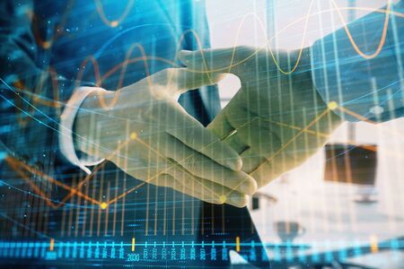 Multi exposure of financial graph on office background with two businessmen handshake. Concept of success in businessの写真素材