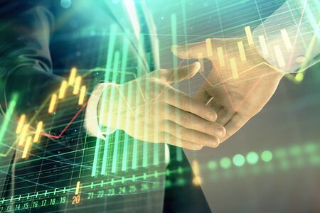 Multi exposure of forex graph on abstract background with two businessmen handshake. Concept of success on stock marketの写真素材