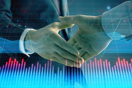 Multi exposure of forex graph on abstract background with two businessmen handshake. Concept of success on stock marketの写真素材