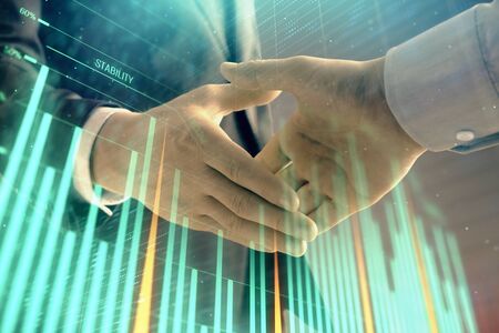 Multi exposure of forex graph on abstract background with two businessmen handshake. Concept of success on stock marketの写真素材
