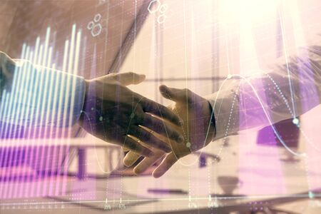 Multi exposure of financial graph on office background with two businessmen handshake. Concept of success in businessの写真素材
