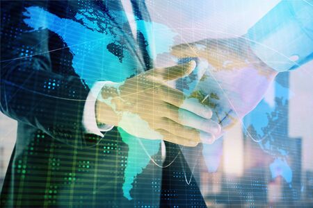 Double exposure of world map on cityscape background with two businessmen handshake. Concept of international businessの写真素材