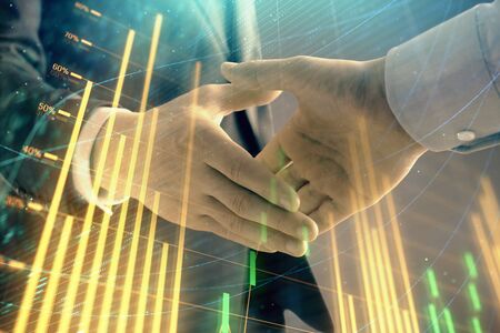 Multi exposure of forex graph on abstract background with two businessmen handshake. Concept of...