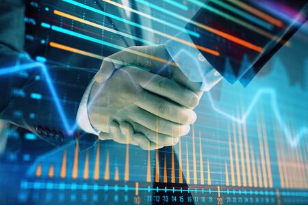 Multi exposure of forex graph on abstract background with two businessmen handshake. Concept of success on stock marketの写真素材
