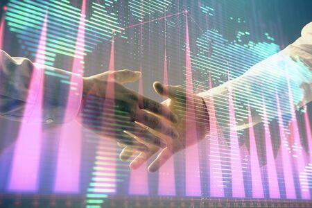 Multi exposure of forex graph and world map on abstract background with two businessmen handshake. Concept of success on international marketsの写真素材