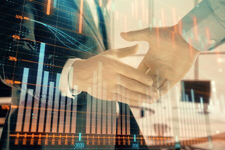 Multi exposure of financial graph on office background with two businessmen handshake. Concept of success in businessの写真素材