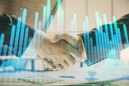 Multi exposure of financial graph on office background with two businessmen handshake. Concept of success in businessの写真素材