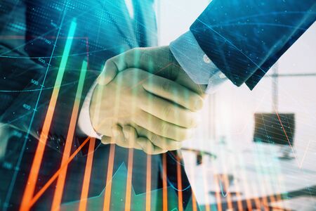 Multi exposure of financial graph on office background with two businessmen handshake. Concept of success in businessの写真素材