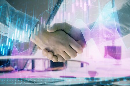 Multi exposure of financial graph on office background with two businessmen handshake. Concept of success in businessの写真素材