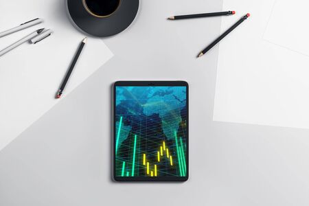 Digital tablet closeup top view with financial graph and partial world map on screen. Online international trading application concept. 3d rendering.の写真素材