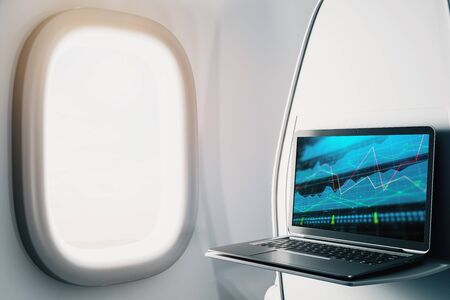Laptop closeup inside airplane with forex graph on screen. Financial market trading concept. 3d rendering.の写真素材