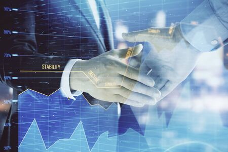 Double exposure of financial chart on cityscape background with two businessmen handshake. Concept of financial analysis and investment opportunitiesの写真素材