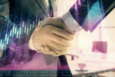 Multi exposure of financial graph on office background with two businessmen handshake. Concept of...