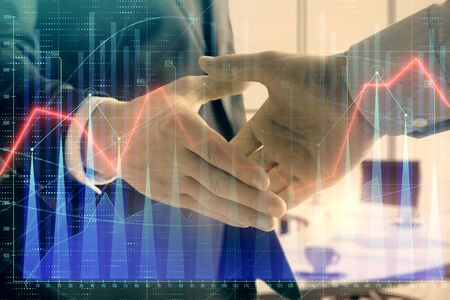 Multi exposure of financial graph on office background with two businessmen handshake. Concept of success in businessの写真素材