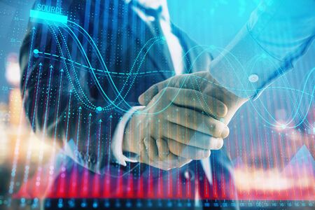 Double exposure of financial chart on cityscape background with two businessmen handshake. Concept of financial analysis and investment opportunitiesの写真素材