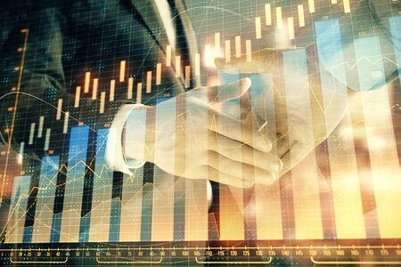 Double exposure of financial chart on cityscape background with two businessmen handshake. Concept of financial analysis and investment opportunitiesの写真素材