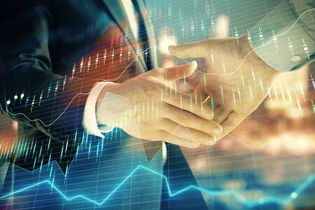 Double exposure of financial chart on cityscape background with two businessmen handshake. Concept of financial analysis and investment opportunitiesの写真素材