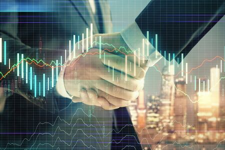 Double exposure of financial chart on cityscape background with two businessmen handshake. Concept of financial analysis and investment opportunitiesの写真素材