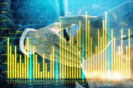 Double exposure of financial chart on cityscape background with two businessmen handshake. Concept of financial analysis and investment opportunitiesの写真素材
