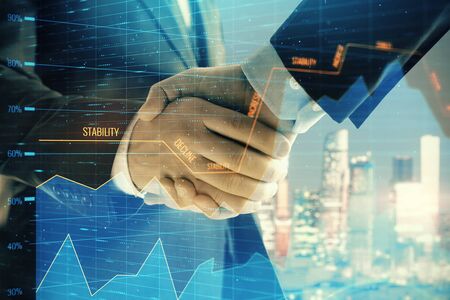 Double exposure of financial chart on cityscape background with two businessmen handshake. Concept of financial analysis and investment opportunitiesの写真素材