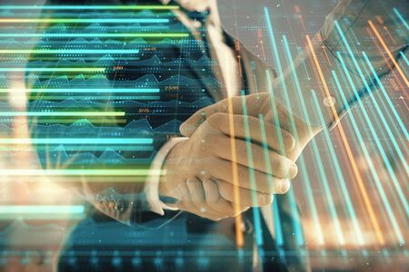 Double exposure of financial chart on cityscape background with two businessmen handshake. Concept of financial analysis and investment opportunitiesの写真素材