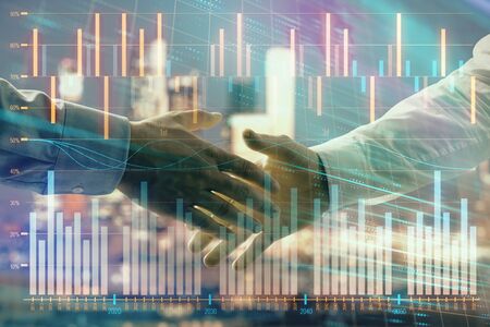 Double exposure of financial chart on cityscape background with two businessmen handshake. Concept of financial analysis and investment opportunitiesの写真素材